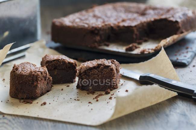 Chocolate brownies on paper — Stock Photo