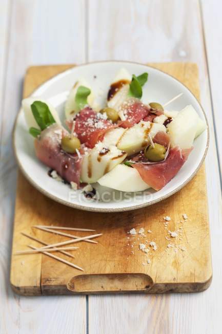 Melon with ham and balsamic sauce — Stock Photo