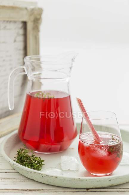 Rhubarb iced tea in glass and jug — Stock Photo