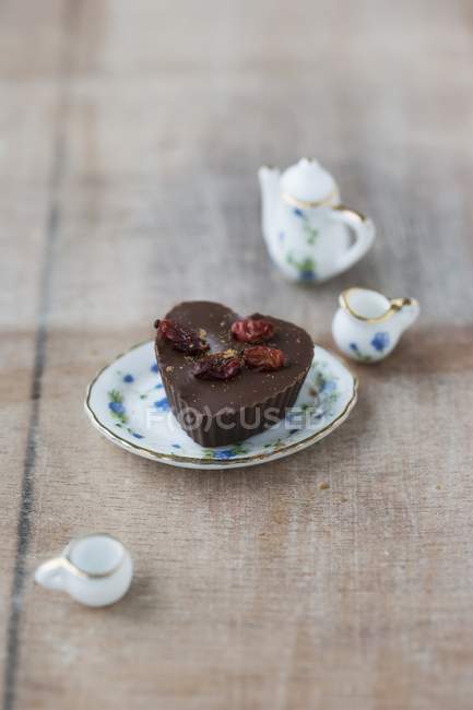 Closeup view of praline with dried barberries on small porcelain plate — Stock Photo