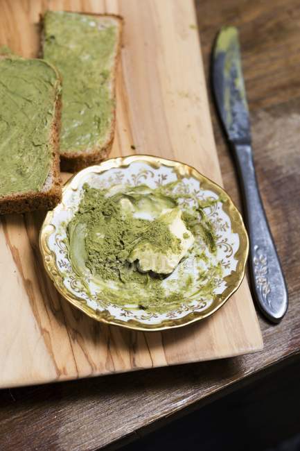 Matcha butter as a spread on wooden desk with knife — Stock Photo