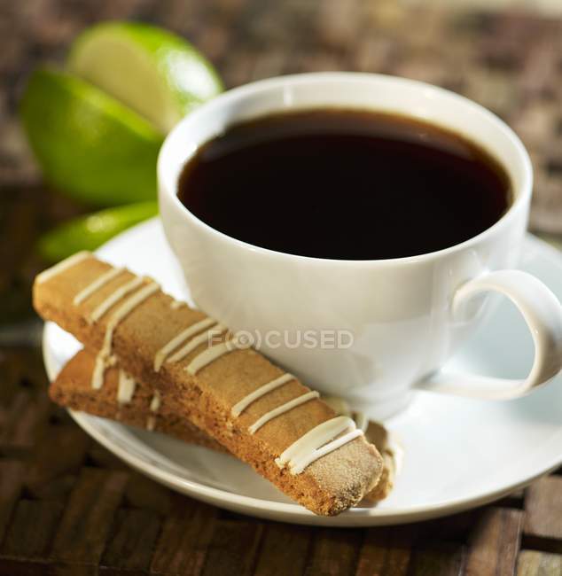 Closeup view of Biscotti with a lime glaze by cup of coffee — Stock Photo