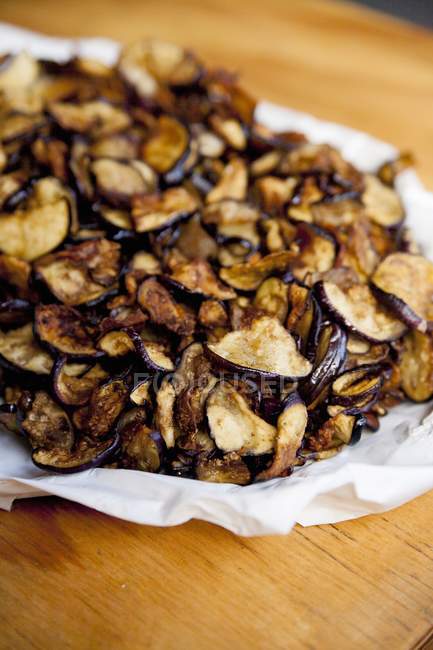 Pile of aubergine chips on paper — Stock Photo