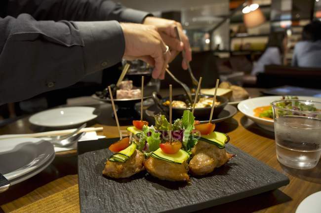 Spiedini di petto di pollo con zucchine e pomodorini in un ristorante — Foto stock