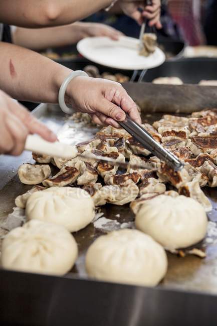 Nahaufnahme von Händen, die ramponiertes Krabbenfleisch auf einem Grill arrangieren — Stockfoto