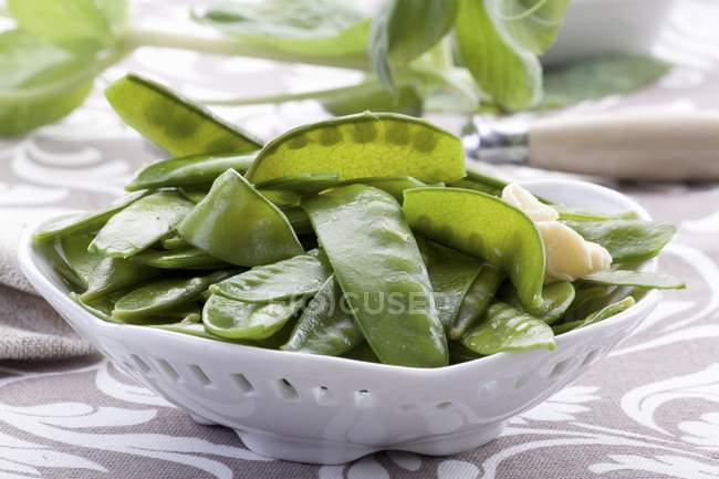 Mange tout with butter  on white plate — Stock Photo