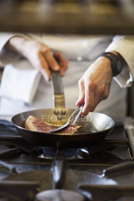 Koch bereitet Steak zu — Stockfoto