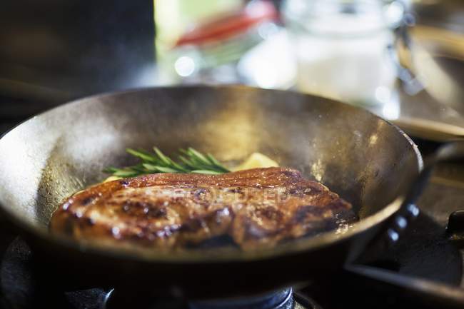 Fried beef steak in frying pan — Stock Photo