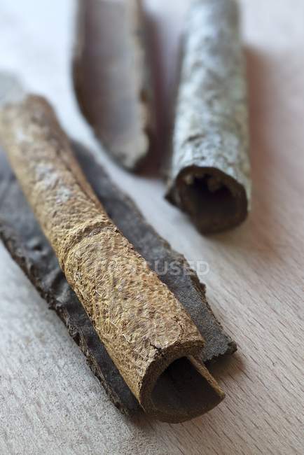 Vue rapprochée de l'écorce de cannelle sur la surface en bois — Photo de stock