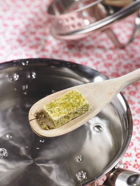 Vue rapprochée de la préparation simple de bouillon de légumes avec un cube de bouillon — Photo de stock