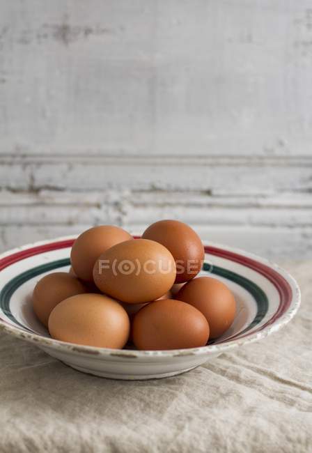 Fresh brown eggs on ceramic plate — Stock Photo