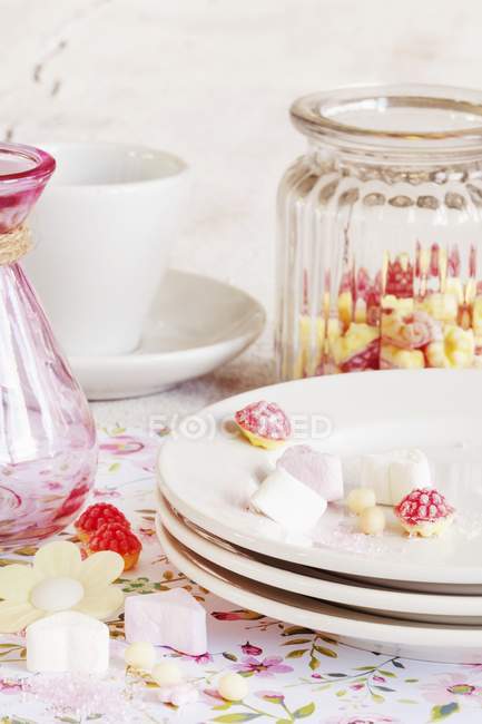 Vista ravvicinata di diverse caramelle con piatti, barattolo e tazza — Foto stock