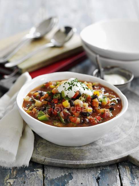 Фасолевый суп с черной фасолью и овощами в белой тарелке — стоковое фото
