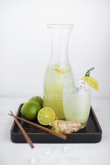 Closeup view of ginger and lime soda with ingredients on a varnished tray — Stock Photo