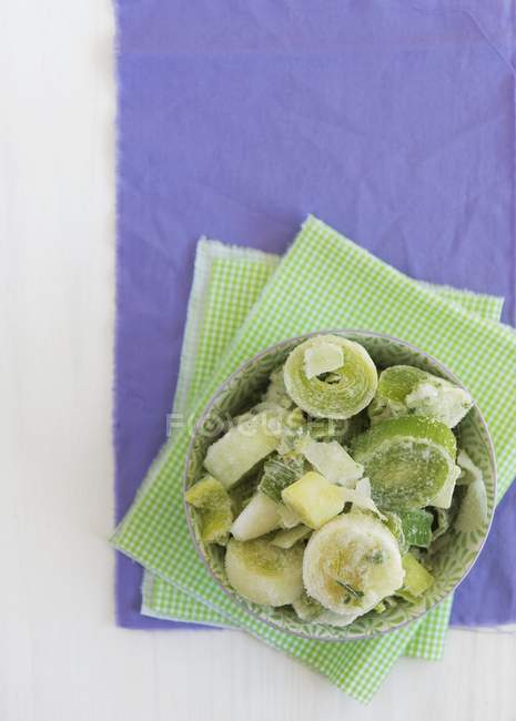 Frozen leek rings on green paper napkins over purple surface — Stock Photo