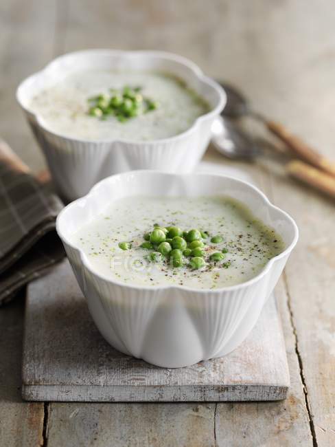 Lettuce soup with peas in white pots — Stock Photo