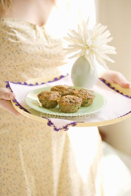 Frau hält ein Tablett mit Cupcakes — Stockfoto