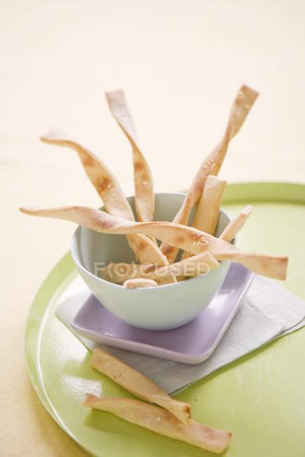 Bowl of breadsticks on plate — Stock Photo