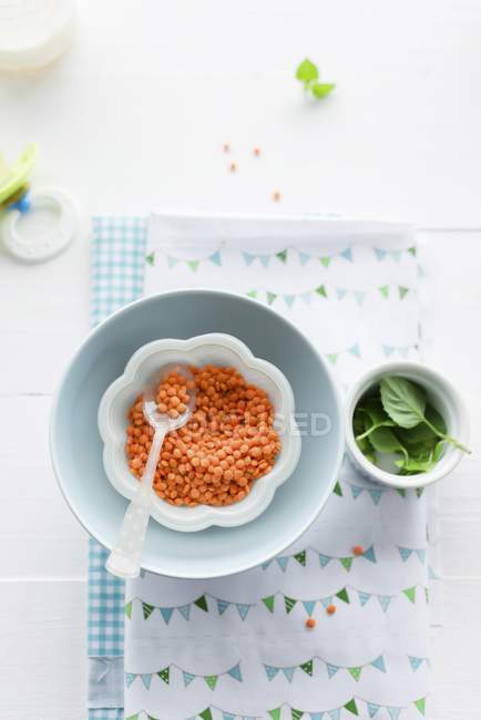 Vista dall'alto delle lenticchie rosse in una ciotola con un cucchiaio — Foto stock