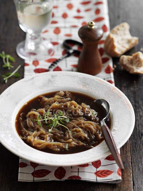 Traditional French onion soup  on white plate with spoon — Stock Photo