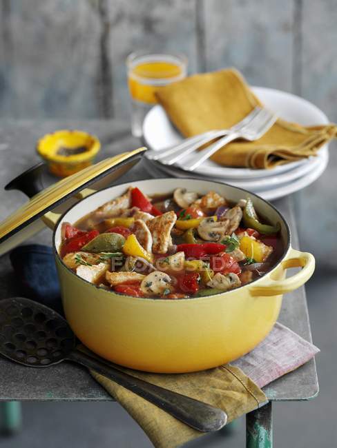 Vegetable stew with turkey in yellow pan  over towel on table — Stock Photo