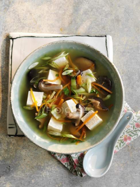 Top view of clear broth with mushrooms and Tofu cheese — Stock Photo