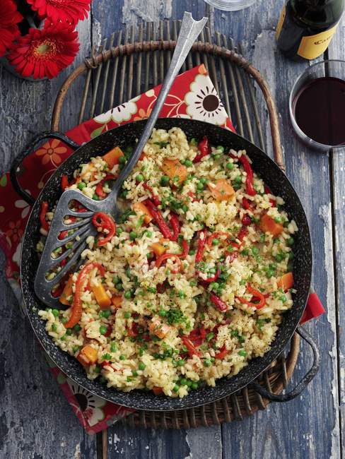 Vegetable paella in a pan over grey wooden surface — Stock Photo