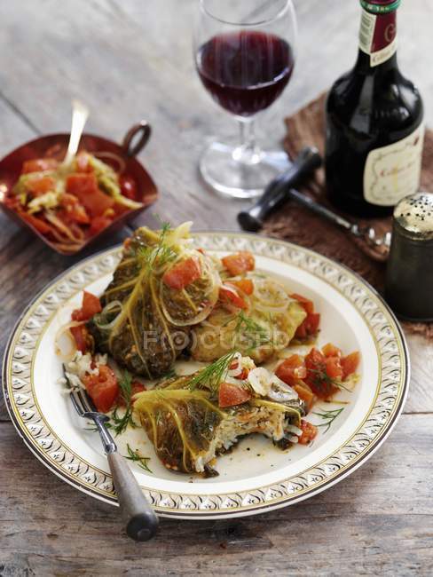 Stuffed savoy cabbage leaves braised on a low heat on white plate  with fork  over wooden surface — Stock Photo