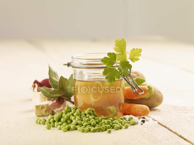 Ingredients for pea soup in glass jar over wooden surface — Stock Photo