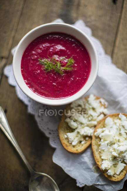 Beetroot soup served with slices of bread — Stock Photo