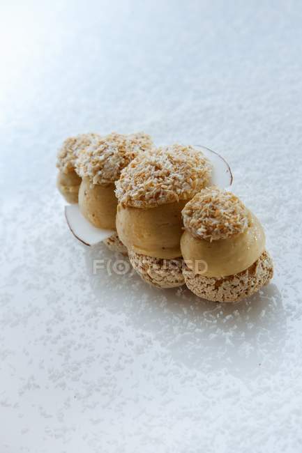 Vue rapprochée de la noix de coco Paris-Brest dessert avec glaçage sur surface blanche — Photo de stock