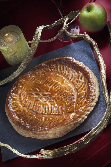 Galette des Rois with an apple filling over red surface — Stock Photo