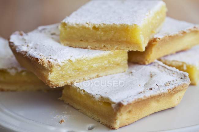 Vista de cerca de rodajas de pastel de limón con azúcar glaseado - foto de stock