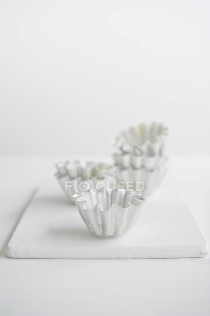 Closeup view of Brioche tins on a white chopping board — Stock Photo