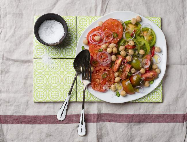 Салат из гороха и помидоров с луковыми кольцами — стоковое фото