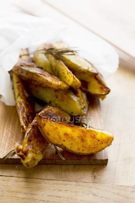 Roasted potato wedges in paper — Stock Photo