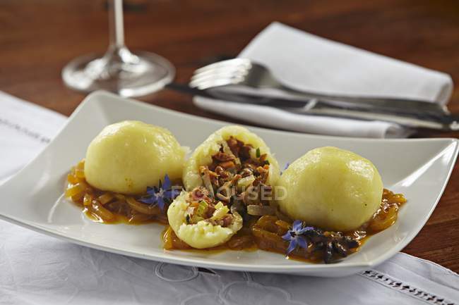Pilzknödel - Kartoffelknödel gefüllt mit Pilzen auf weißem Teller über Handtuch — Stockfoto