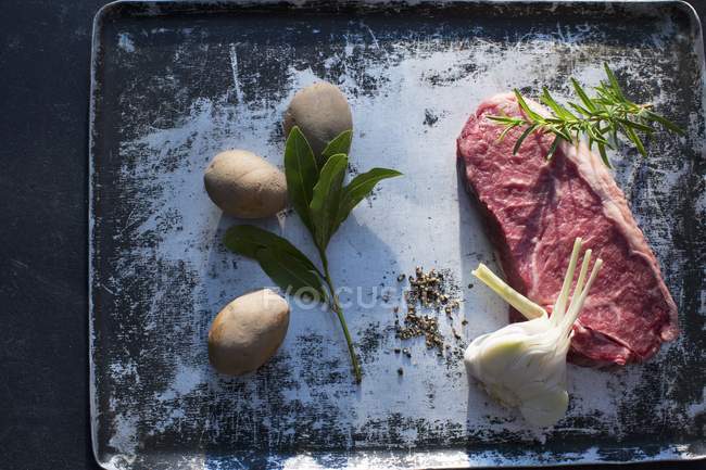 Raw Beef steak with garlic and potatoes — Stock Photo
