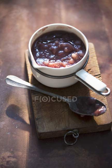 Onion chutney in a saucepan over wooden desk — Stock Photo
