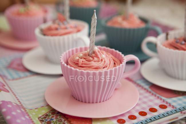 Pink cupcakes with birthday candles — Stock Photo