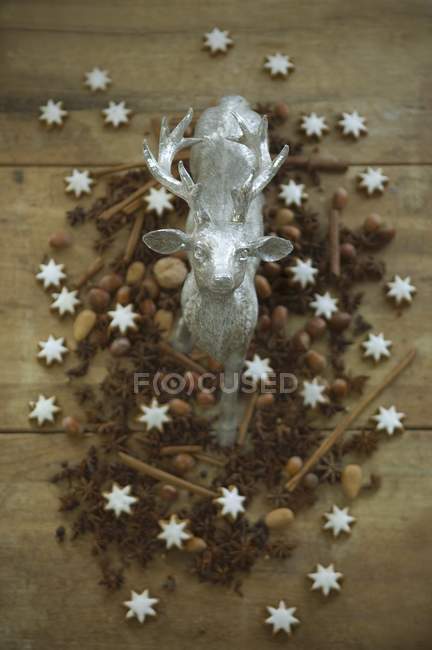 Статуэтка оленя в окружении орехов — стоковое фото