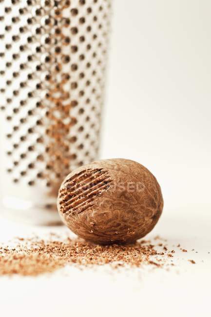 Raw whole nutmeg with grater — Stock Photo