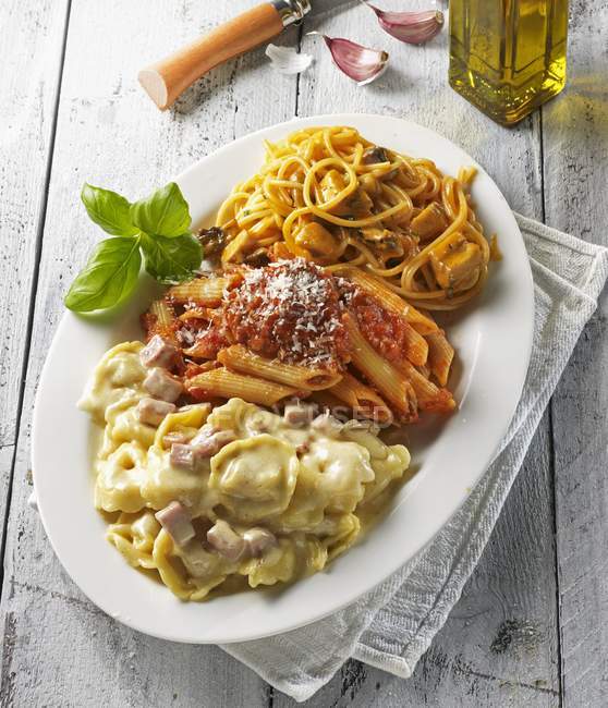 Three pasta dishes on platter — Stock Photo