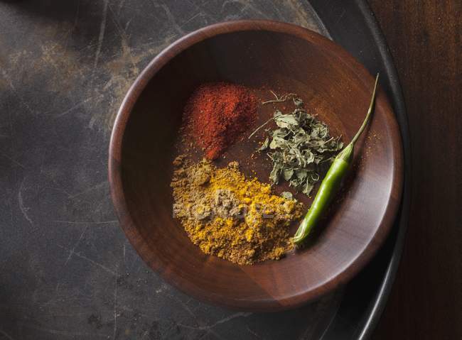 Индийские специи и зеленый чили в деревянной чаше на подносе — стоковое фото