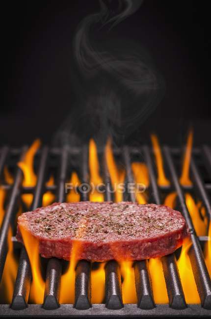 Hambúrguer cru em churrasco flamejante — Fotografia de Stock
