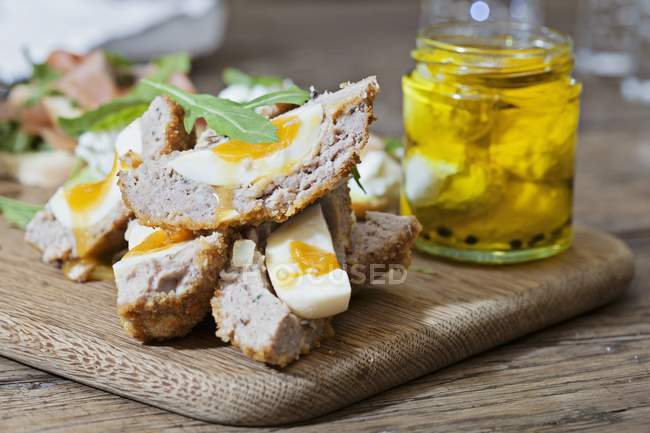 Closeup view of Scotch eggs on a wooden chopping board — Stock Photo