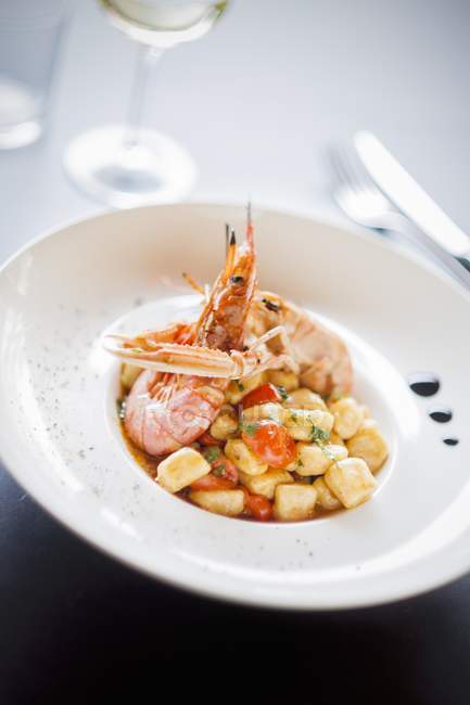 Gnocchi con crustáceos en plato blanco - foto de stock