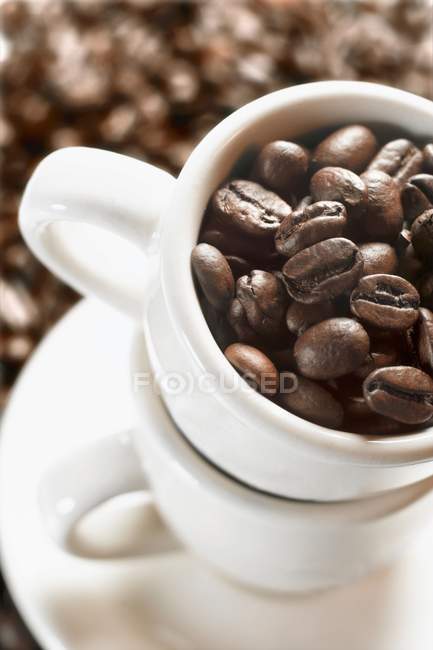 Granos de café en tazas de café expreso - foto de stock