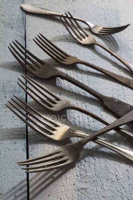 Closeup view of old forks on a wooden surface — Stock Photo