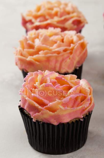 Fila de cupcakes de Rose - foto de stock